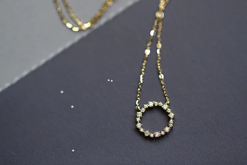 Colar dourado círculo cravejado de zircônia em close, Loja Simplicité