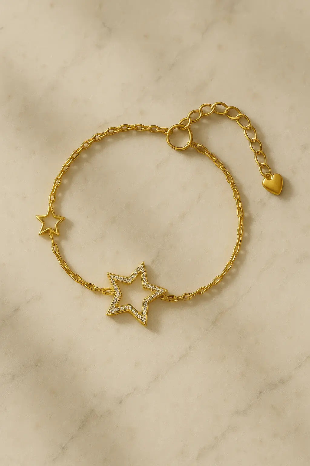 Pulseira minimalista estrela vazada dourada sobre pedra natural clara