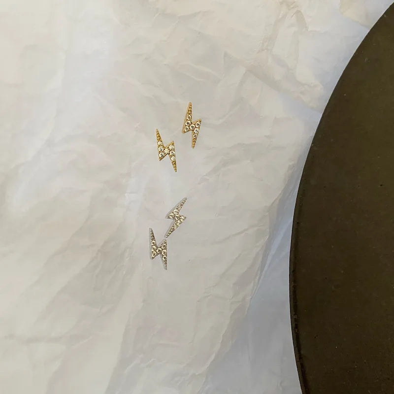 Brincos dourados de raio com zircônia em destaque - Loja Simplicité