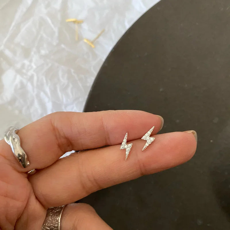 Brincos dourados de raio com zircônia vistos de perto - Loja Simplicité