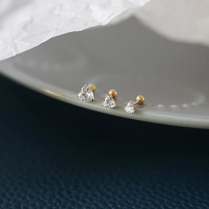 Brincos dourados coração de zircônia usados na orelha – Loja Simplicité