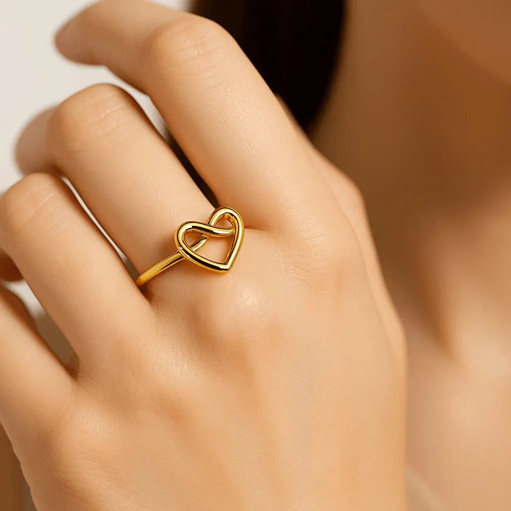 Mão feminina usando anel regulável de coração dourado estilo romântico