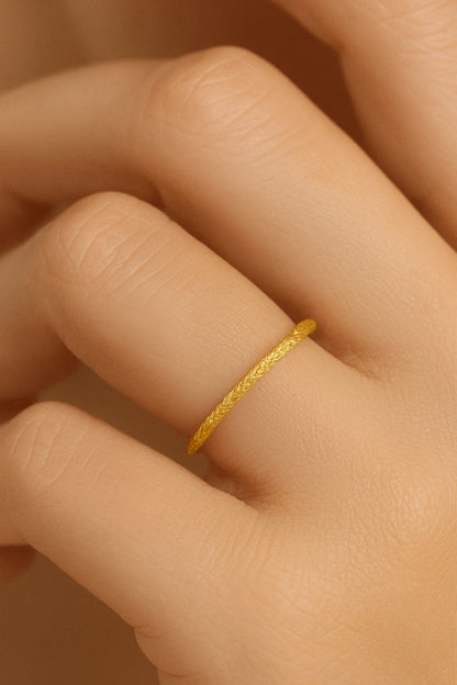 Mão feminina usando anel fininho facetado dourado estilo aparador