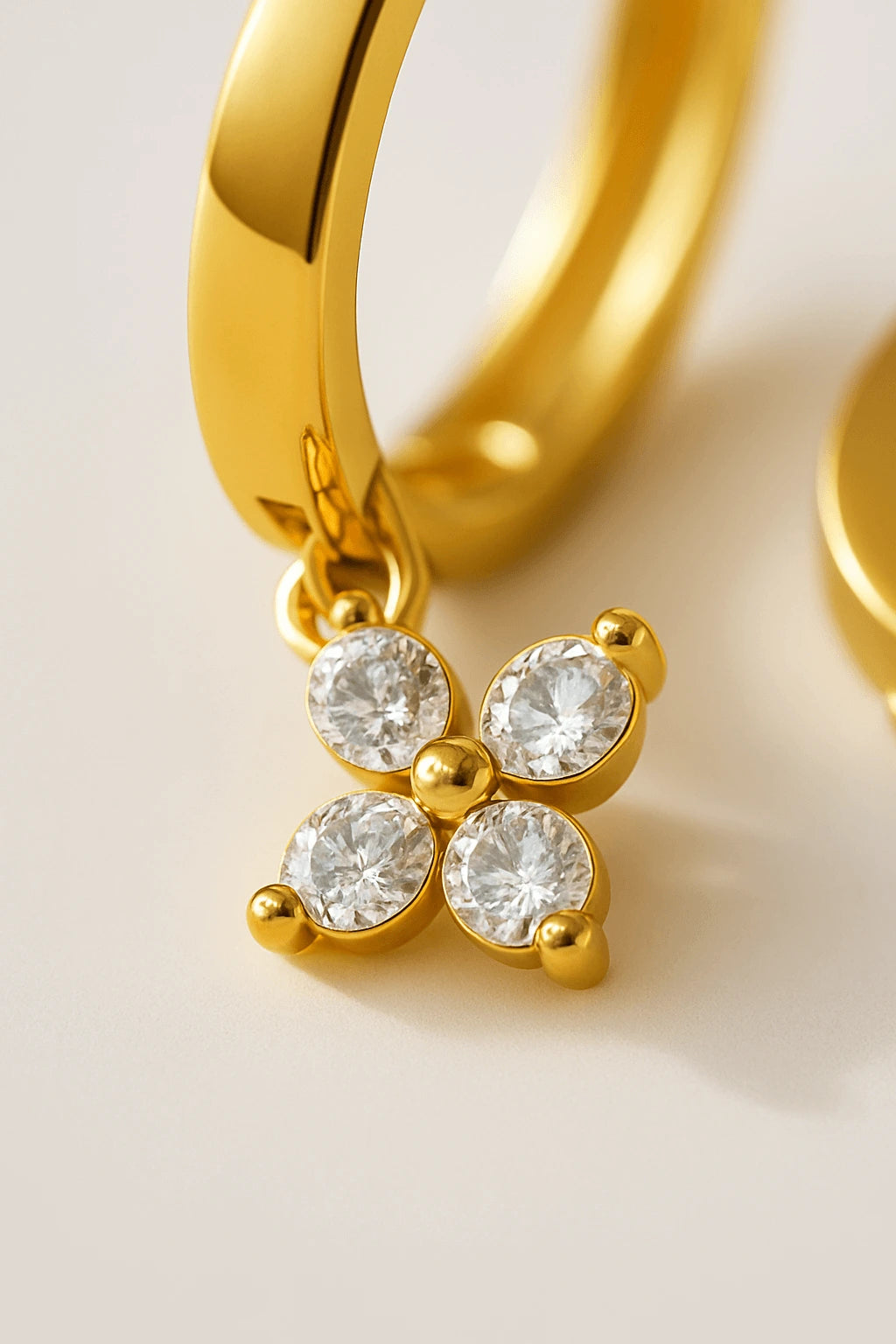 Detalhe macro brinco argola florzinha cravejada zircônia acabamento polido ouro 18k