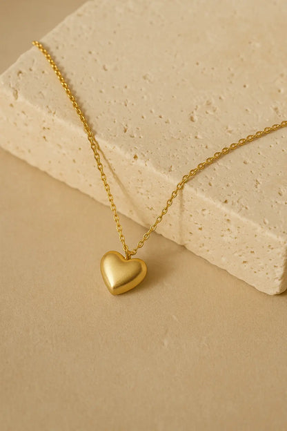 Colar choker minimalista coração liso dourado sobre pedra natural clara