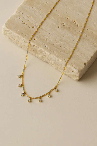 Colar minimalista pedras zircônia movimento dourado sobre pedra natural clara