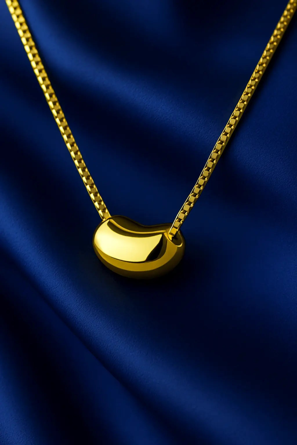 Joia feminina colar pingente orgânico dourado sobre fundo veludo azul royal Simplicité