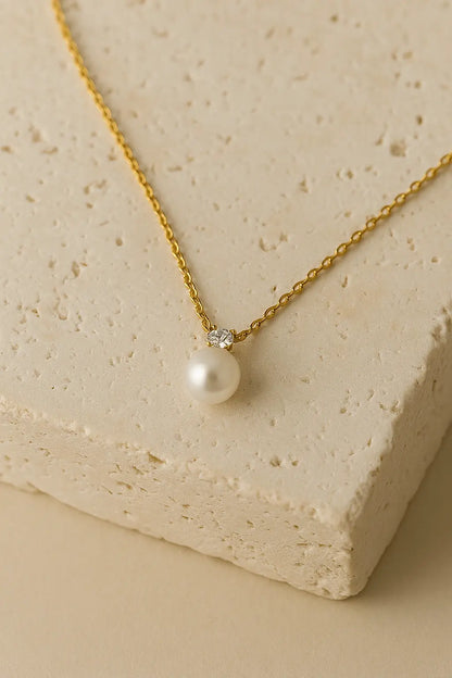 Colar minimalista pérola zircônia dourado sobre pedra natural clara