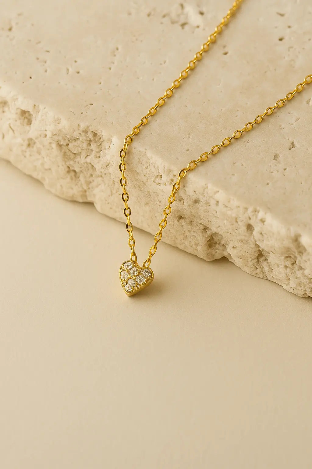 Colar minimalista pingente mini coração dourado sobre pedra natural clara