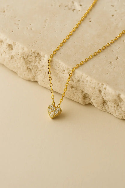 Colar minimalista pingente mini coração dourado sobre pedra natural clara