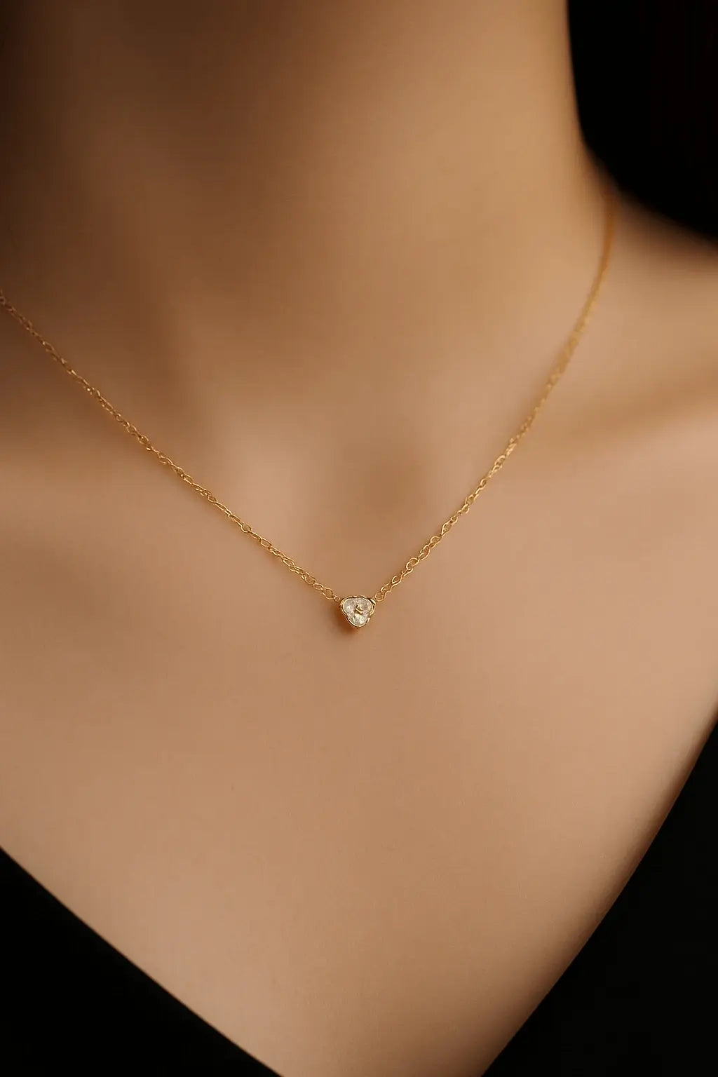 Pescoço feminino usando colar de mini coração dourado estilo sutil e romântico