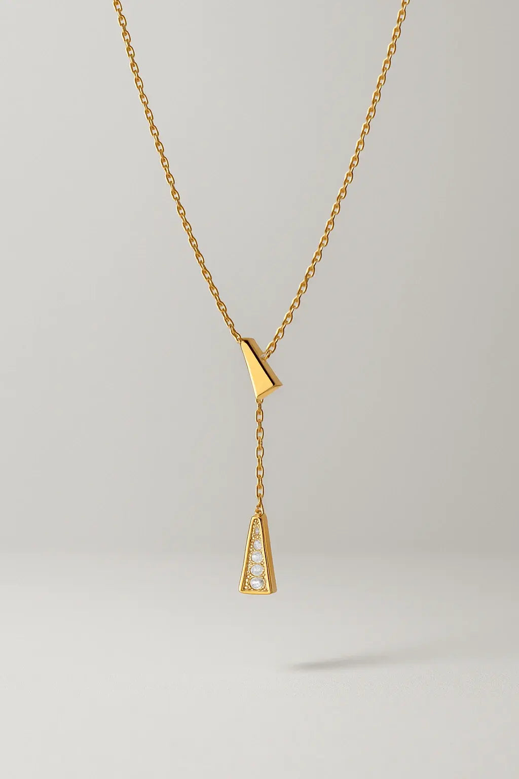 Colar prisma dourado com tassel vista frontal design geométrico moderno