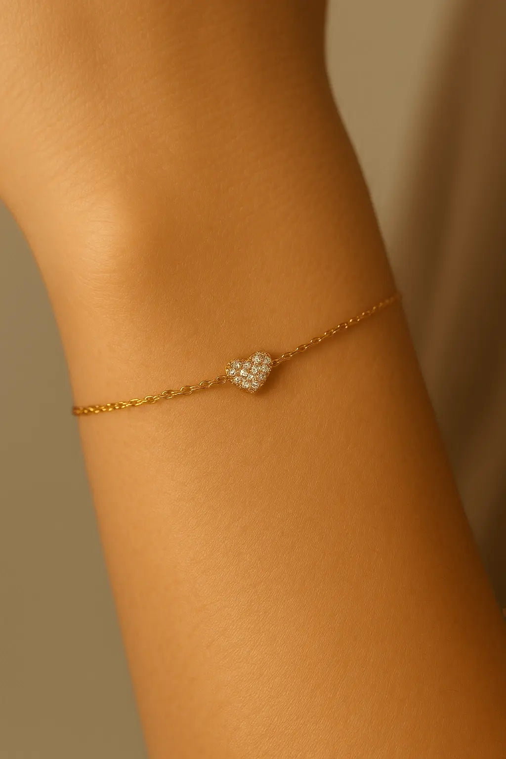 Pulso feminino usando pulseira de coração dourado com zircônias estilo elegante