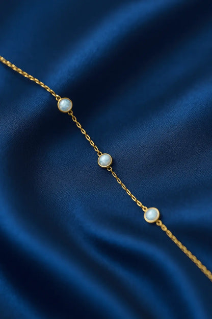 Joia feminina pulseira pedra opalina delicada sobre fundo veludo azul royal Simplicité