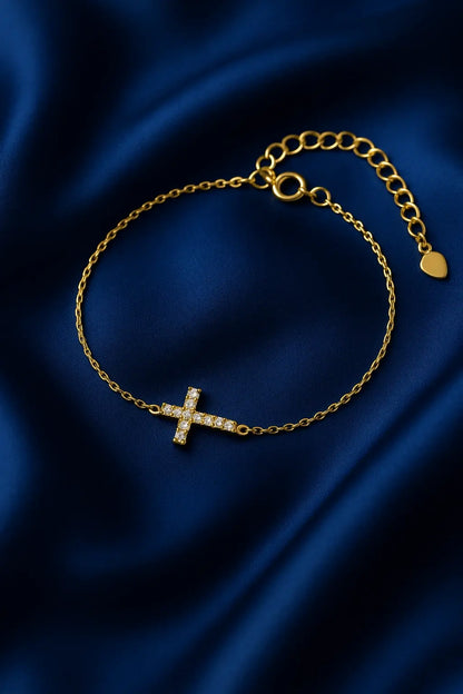 Joia feminina pulseira cruz delicada sobre fundo veludo azul royal Simplicité