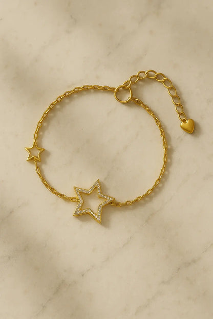 Pulseira minimalista estrela vazada dourada sobre pedra natural clara
