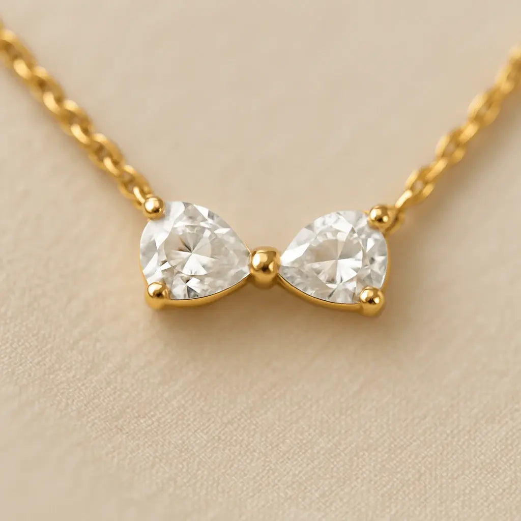 Detalhe macro pulseira pingente formato laço acabamento polido ouro 18k