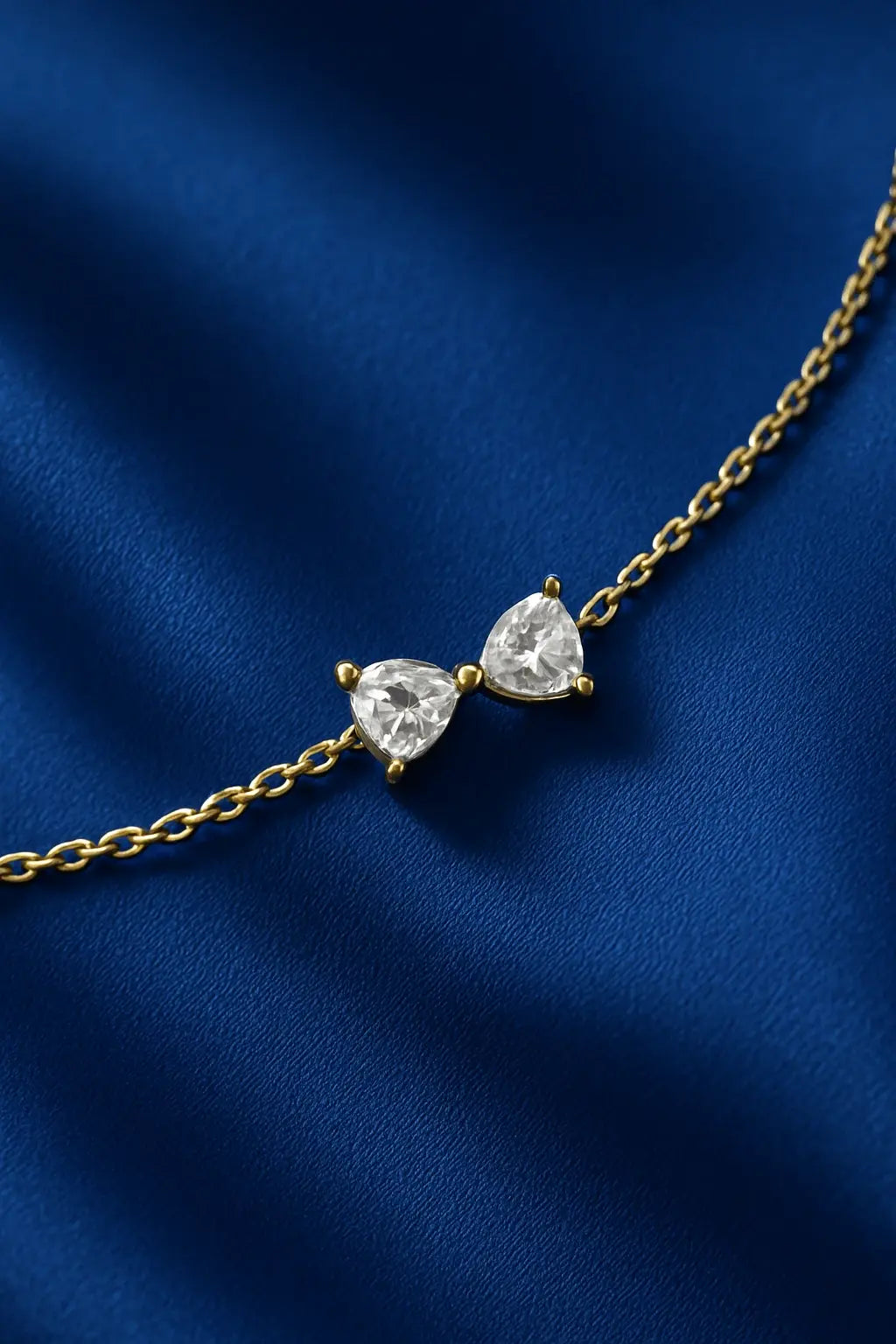 Joia feminina pulseira laço delicado sobre fundo veludo azul royal Simplicité