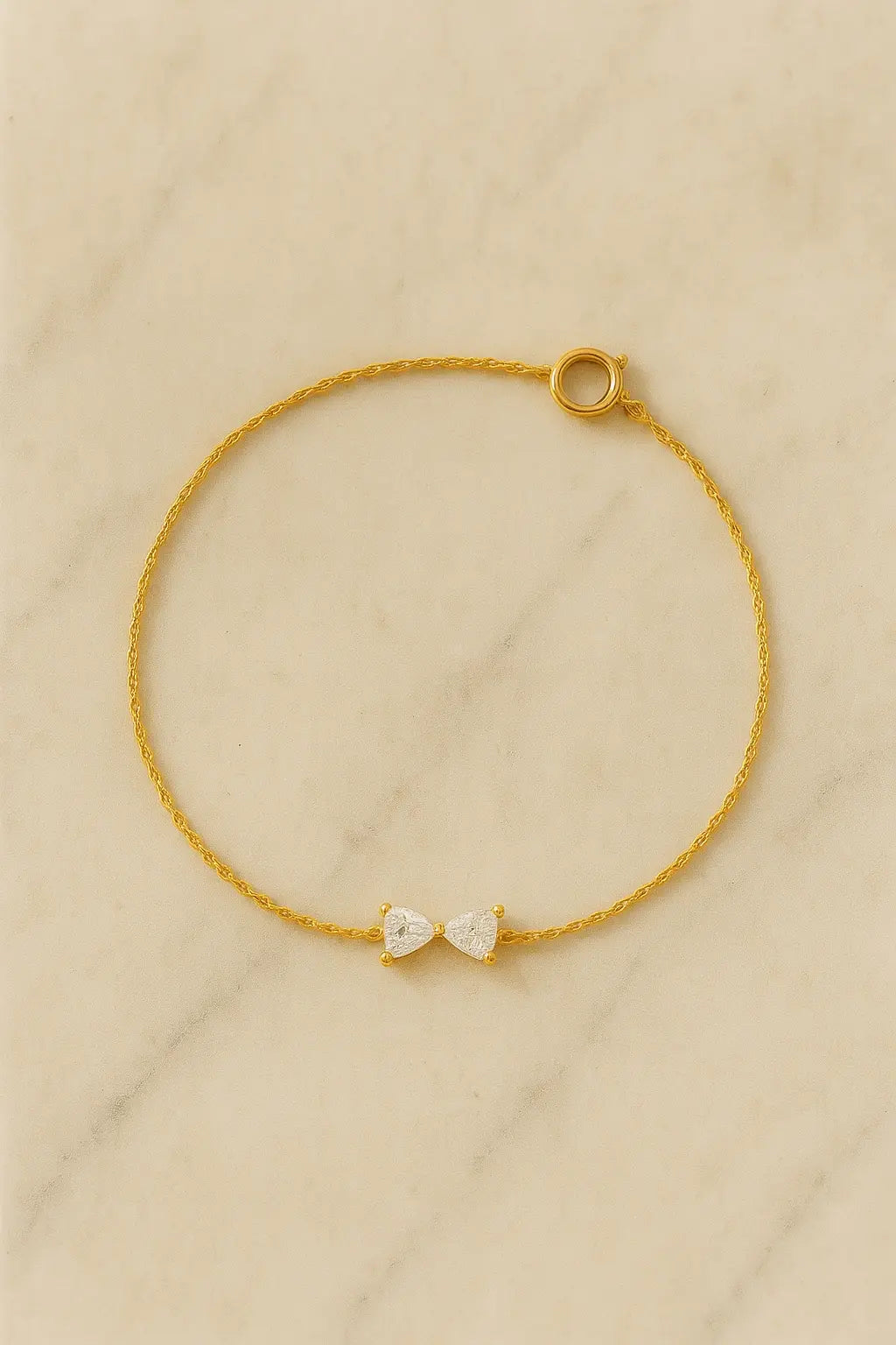 Pulseira minimalista pingente laço dourado sobre pedra natural clara