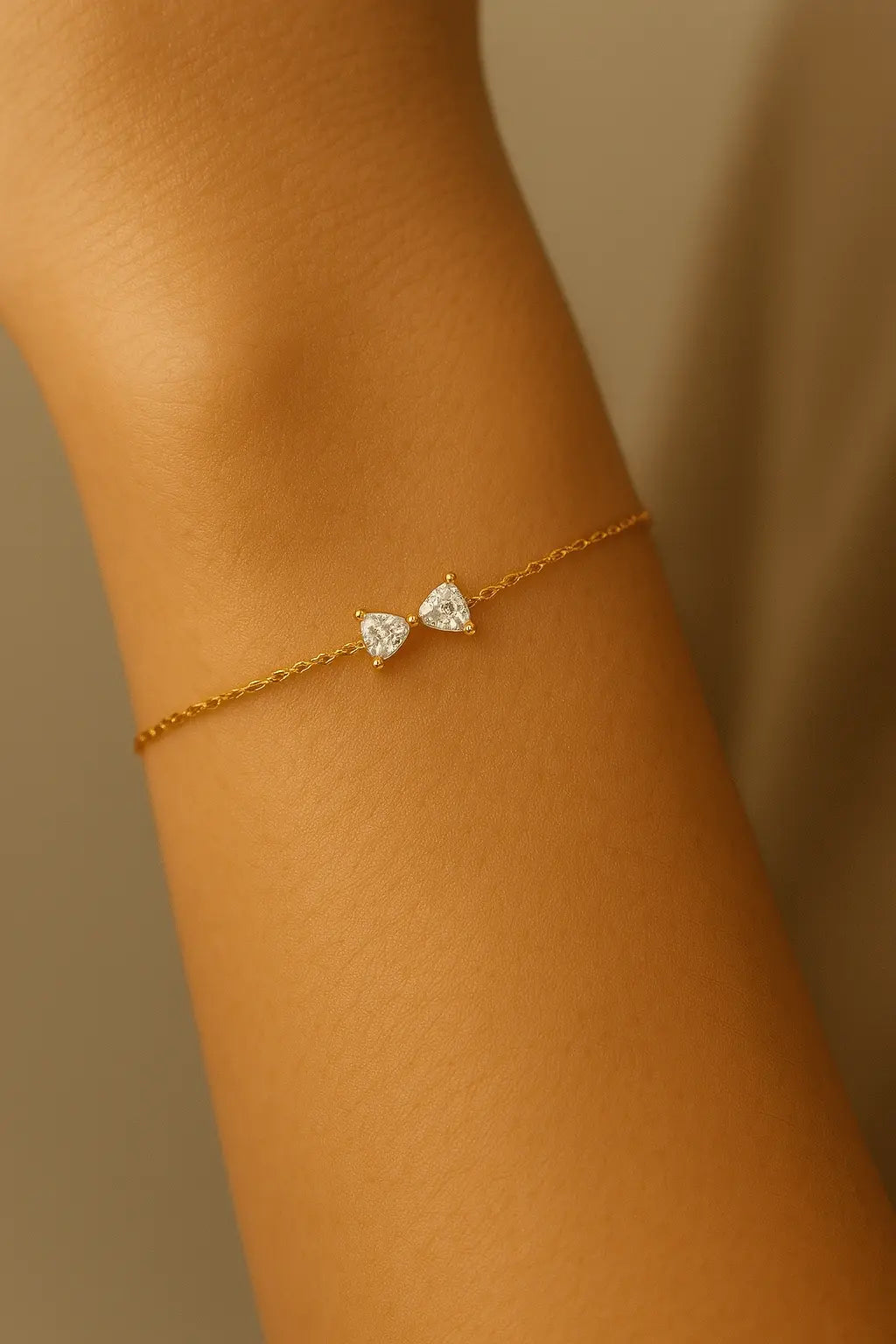 Pulso feminino usando pulseira com pingente de laço dourado estilo delicado