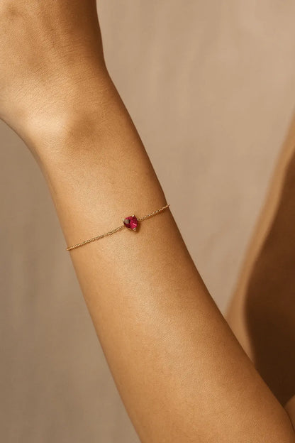 Pulso feminino usando pulseira de coração dourado pequeno estilo sutil