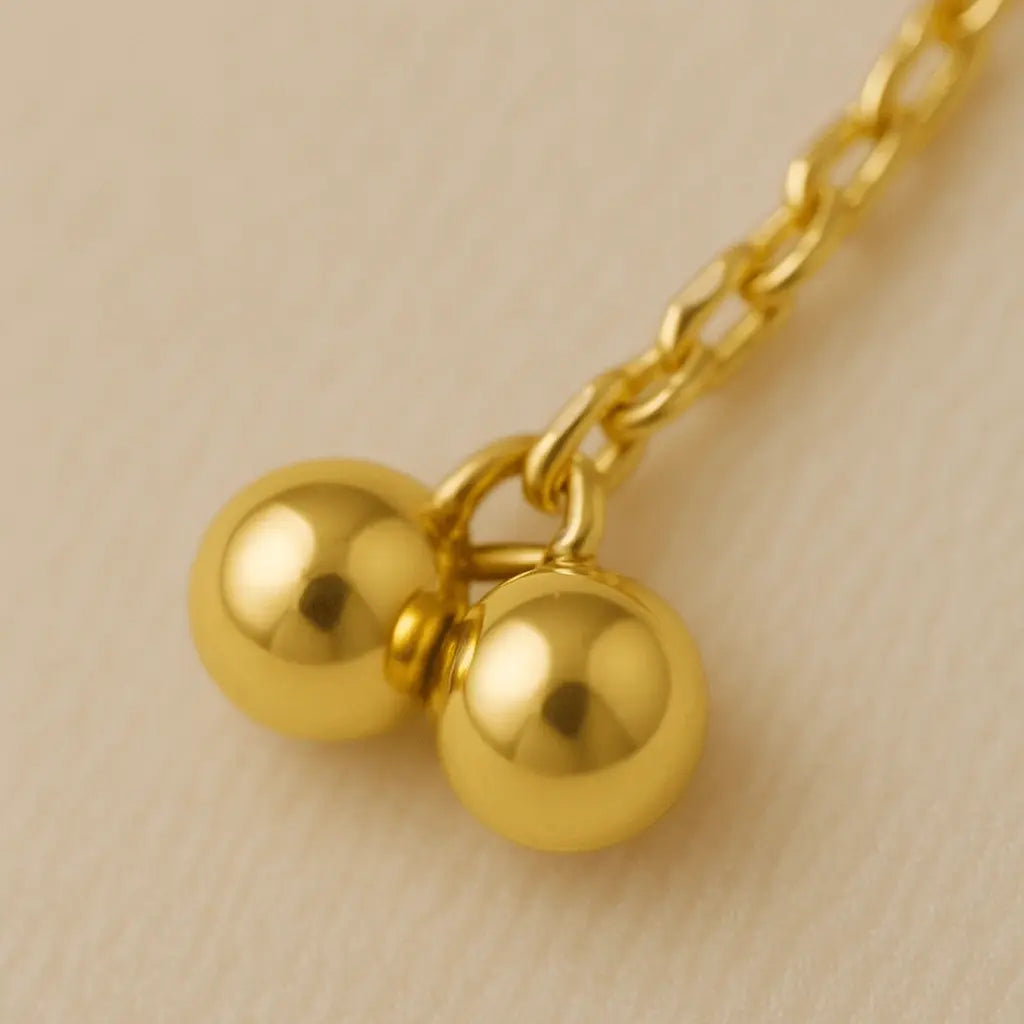 Detalhe macro tornozeleira pingente ponto de luz acabamento polido ouro 18k